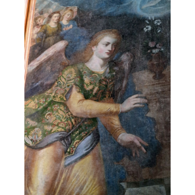 L'ange porte une robe de drap d'or et un pourpoint de velours, semblables à ceux des seigneurs espagnols du temps de l'appartenance de la Comté à l'Espagne .
